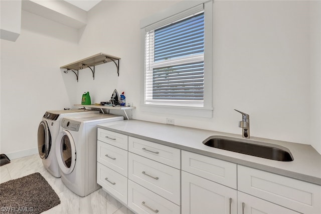 laundry room featuring cabinets, sink, and washing machine and clothes dryer