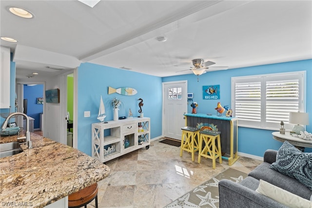 tiled living room featuring ceiling fan and sink