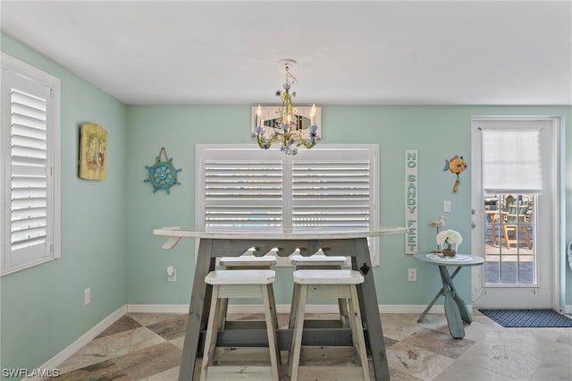 dining area featuring light tile flooring and a notable chandelier