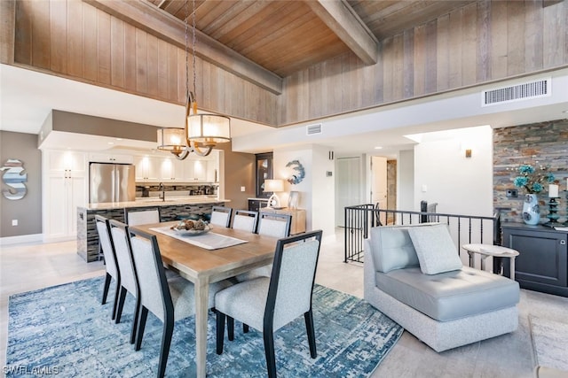 dining space with light tile floors, an inviting chandelier, wood ceiling, a towering ceiling, and sink