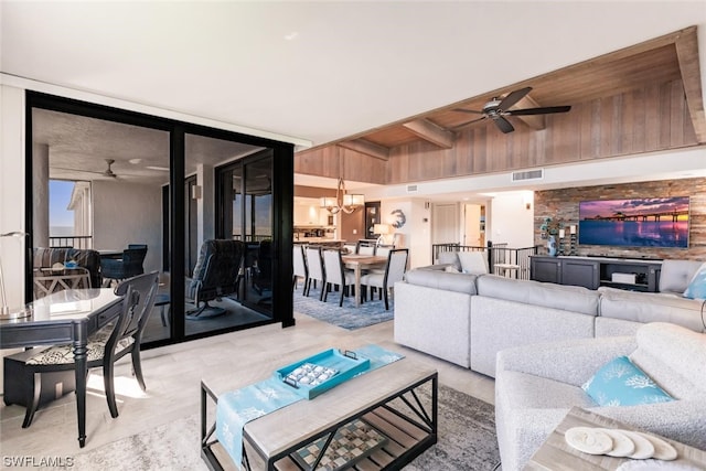 tiled living room featuring ceiling fan with notable chandelier