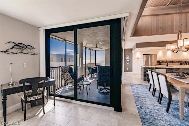 dining area with floor to ceiling windows, light tile floors, sink, and ceiling fan with notable chandelier