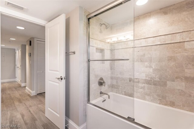 bathroom featuring combined bath / shower with glass door and wood-type flooring