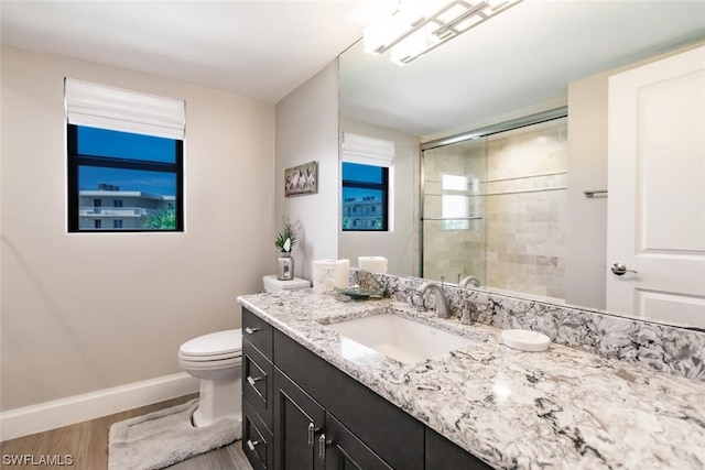 bathroom with hardwood / wood-style flooring, vanity with extensive cabinet space, and toilet