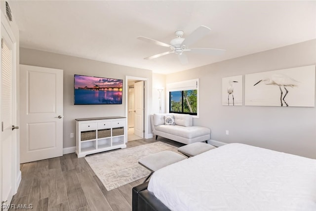 bedroom featuring connected bathroom, ceiling fan, and light hardwood / wood-style flooring