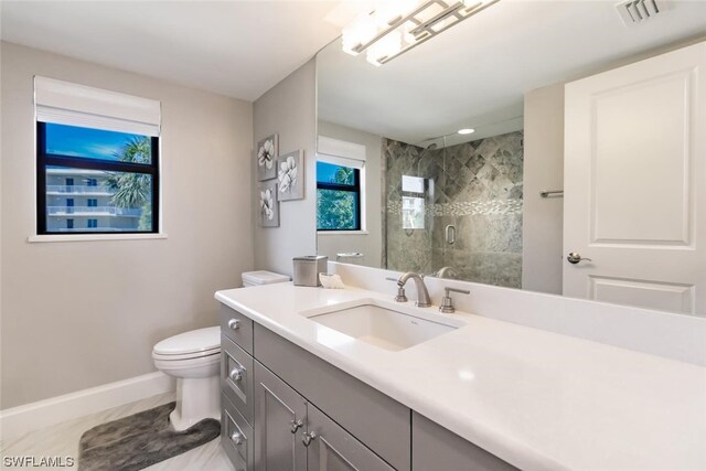 bathroom featuring tile floors, toilet, vanity, and an enclosed shower