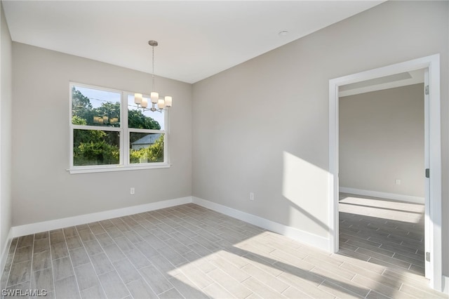 empty room with a notable chandelier and light hardwood / wood-style floors