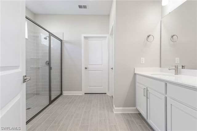 bathroom featuring walk in shower and vanity with extensive cabinet space