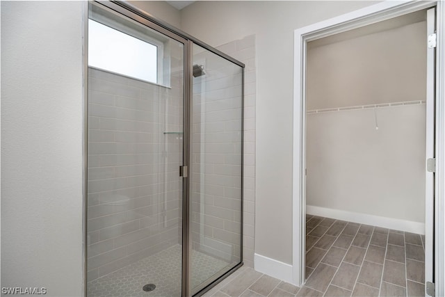 bathroom with a shower with door and tile flooring