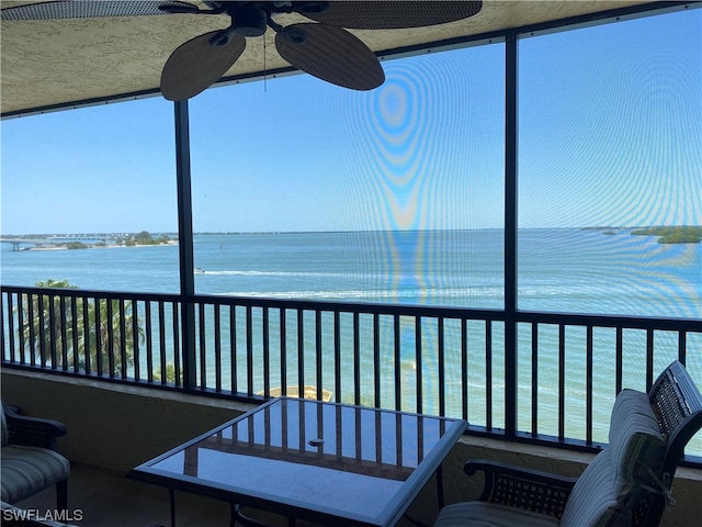 sunroom with a water view and ceiling fan