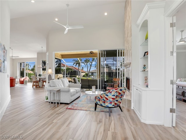 living room featuring light wood-type flooring, vaulted ceiling, and built in features