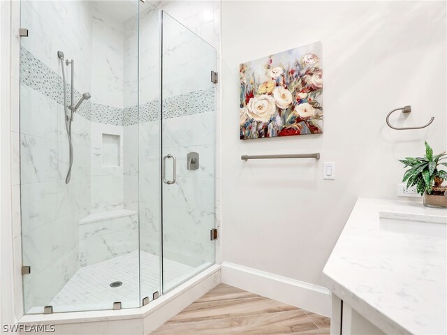 bathroom featuring walk in shower, vanity, and hardwood / wood-style flooring