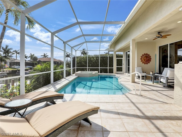 view of swimming pool with a patio, an in ground hot tub, a lanai, and ceiling fan