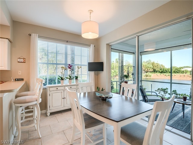 tiled dining space featuring a water view