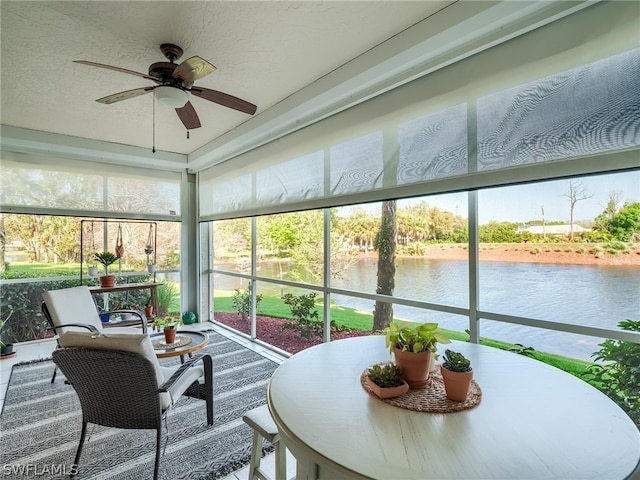 sunroom with a water view and ceiling fan