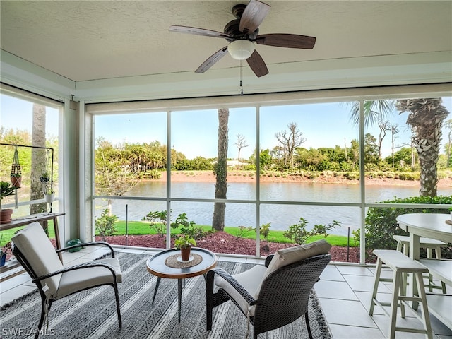 sunroom / solarium featuring a water view and ceiling fan