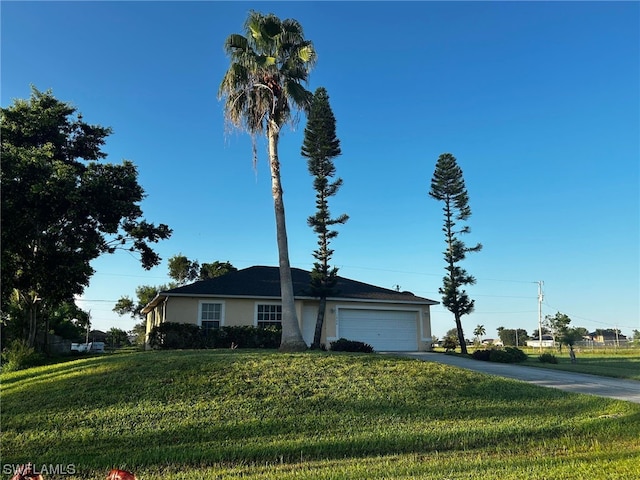 view of front of house featuring a front lawn and a garage