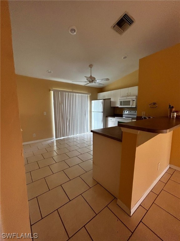 kitchen featuring light tile flooring, ceiling fan, electric range, kitchen peninsula, and stainless steel fridge