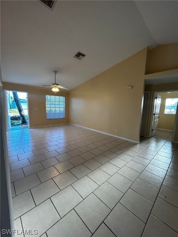 spare room featuring a healthy amount of sunlight, ceiling fan, and light tile floors