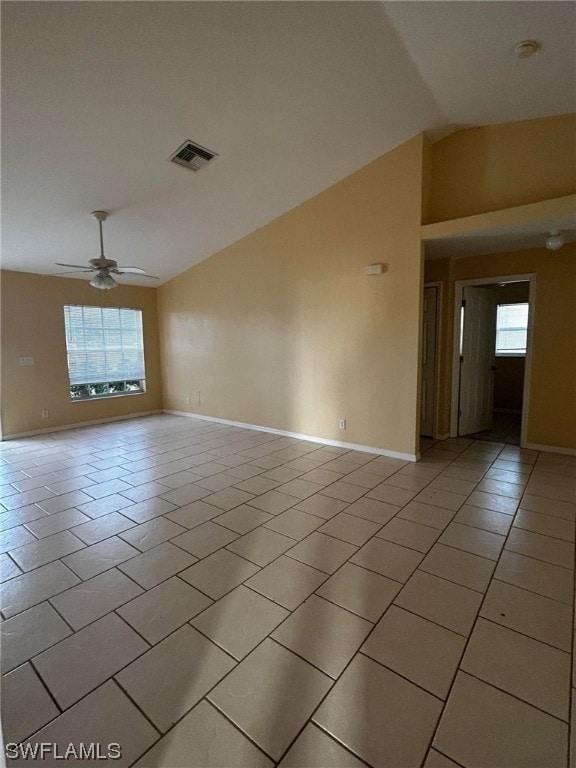 tiled empty room featuring vaulted ceiling and ceiling fan