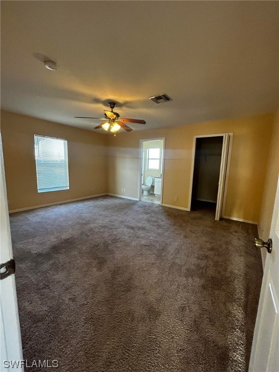 spare room featuring ceiling fan and dark colored carpet