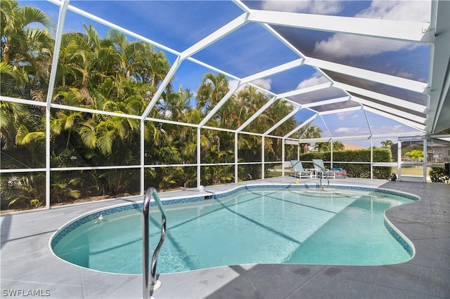 view of swimming pool with glass enclosure and a patio area