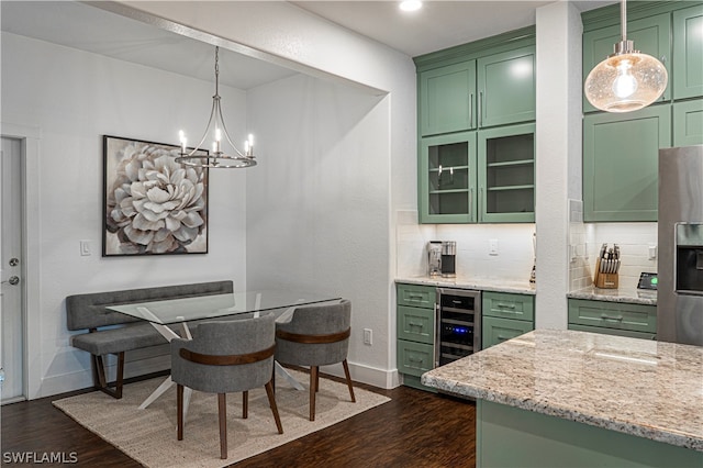 kitchen with pendant lighting, green cabinetry, backsplash, beverage cooler, and dark hardwood / wood-style flooring