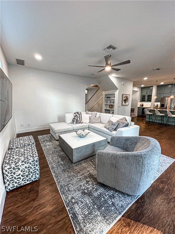 living room featuring ceiling fan and dark hardwood / wood-style flooring