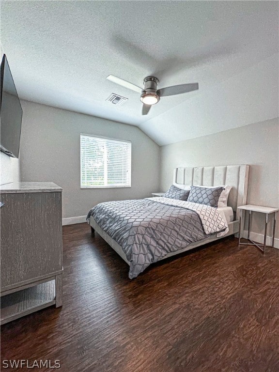 bedroom featuring vaulted ceiling, ceiling fan, a textured ceiling, and dark hardwood / wood-style flooring