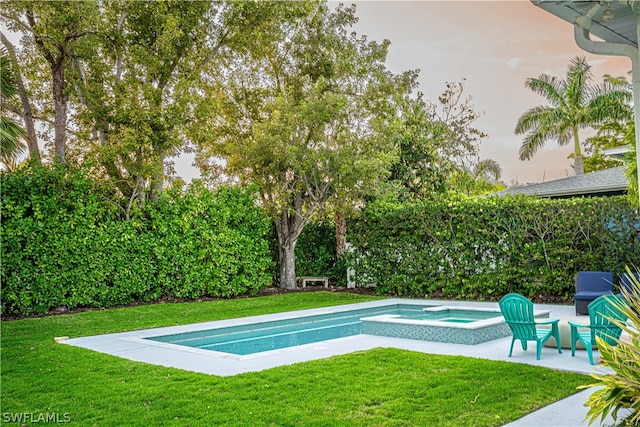 view of pool with a patio, a lawn, and an in ground hot tub