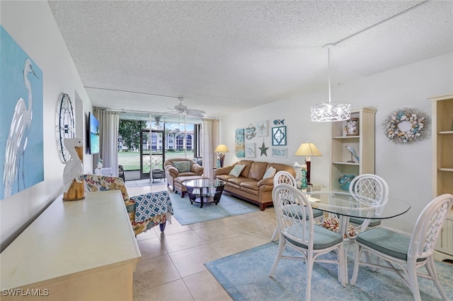 dining area with ceiling fan with notable chandelier, a textured ceiling, and light tile patterned floors