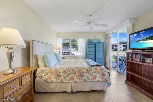 bedroom with a textured ceiling, multiple windows, light tile patterned flooring, and access to exterior