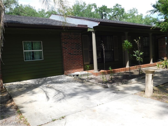 view of exterior entry with a patio area