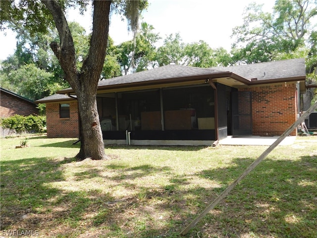 back of house with a sunroom and a yard