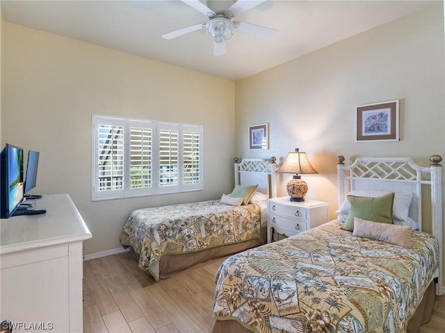 bedroom featuring light wood-style floors, baseboards, and a ceiling fan