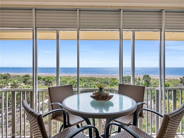 sunroom / solarium with a wealth of natural light, a water view, and a view of the beach