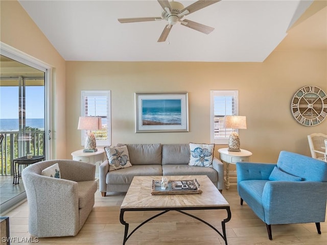 living room featuring light wood-type flooring, a ceiling fan, and lofted ceiling