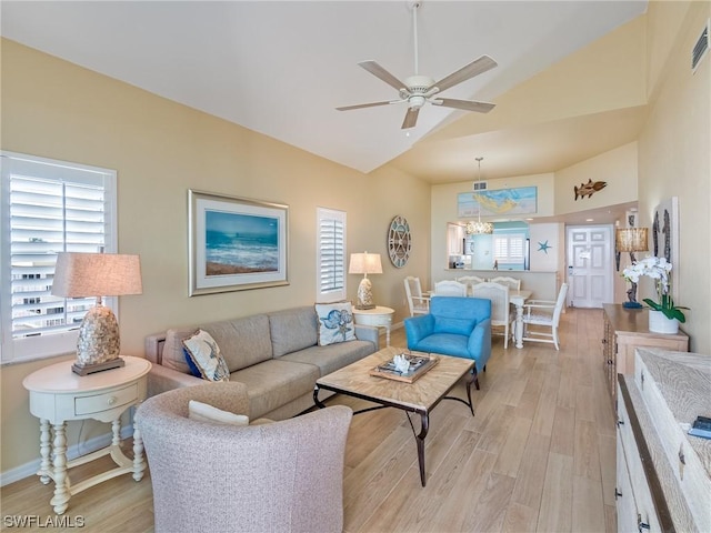 living room with lofted ceiling, light wood-style floors, baseboards, and a ceiling fan