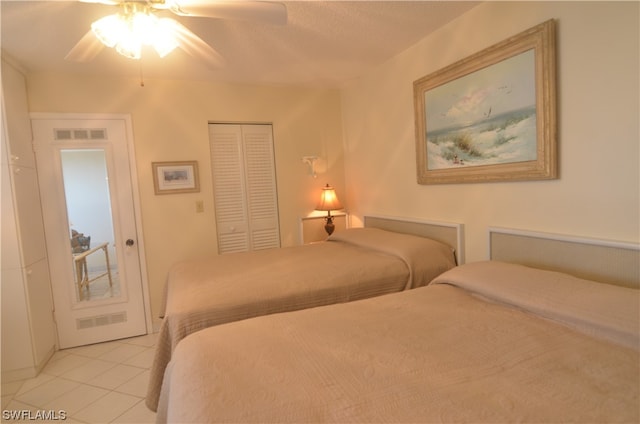 tiled bedroom with a closet and ceiling fan