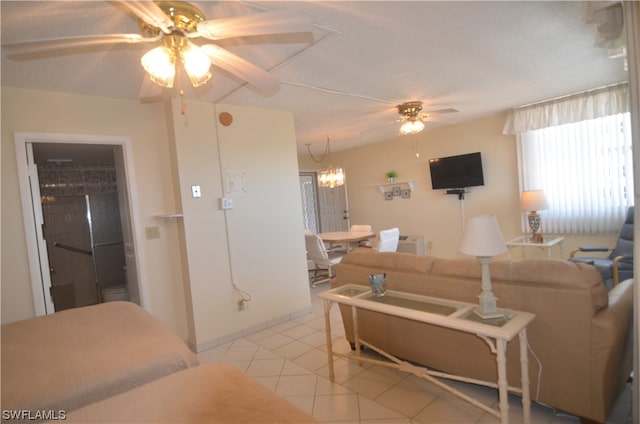 tiled living room with ceiling fan with notable chandelier