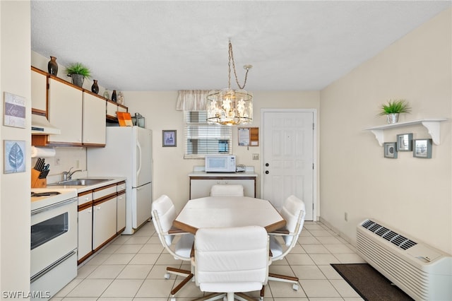 kitchen featuring white cabinets, hanging light fixtures, white appliances, and light tile floors