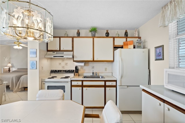 kitchen featuring white appliances, light tile flooring, ceiling fan with notable chandelier, white cabinetry, and sink