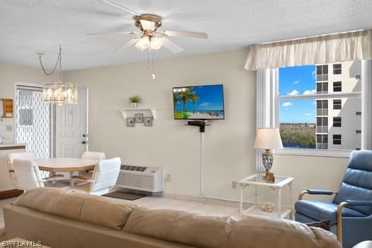 living room with ceiling fan with notable chandelier