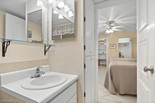 bathroom with tile walls, oversized vanity, ceiling fan, and tile flooring