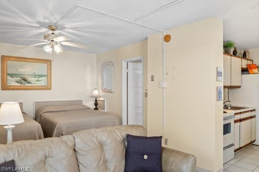 bedroom with sink, ceiling fan, and light tile floors