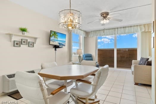 tiled dining room with ceiling fan with notable chandelier