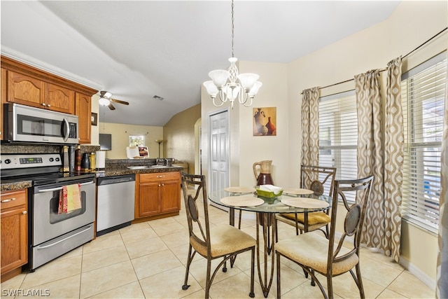 kitchen with stainless steel appliances, light tile flooring, decorative light fixtures, and ceiling fan with notable chandelier