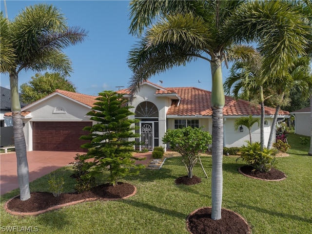 mediterranean / spanish home featuring a front yard and a garage