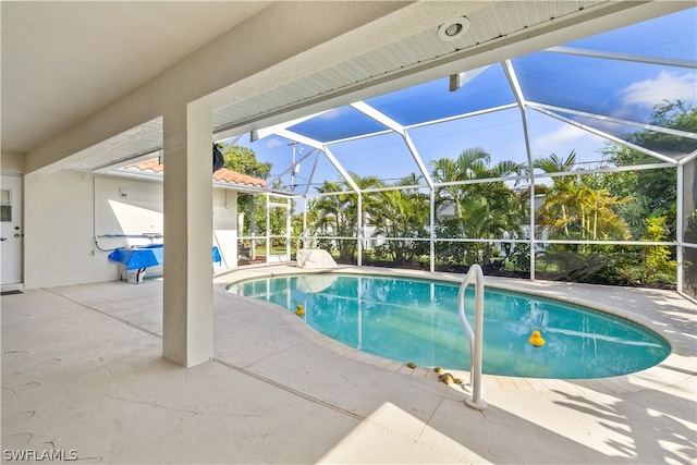 view of swimming pool with a patio and a lanai