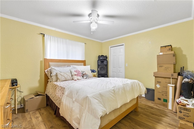 bedroom with ornamental molding, a closet, ceiling fan, and light hardwood / wood-style flooring